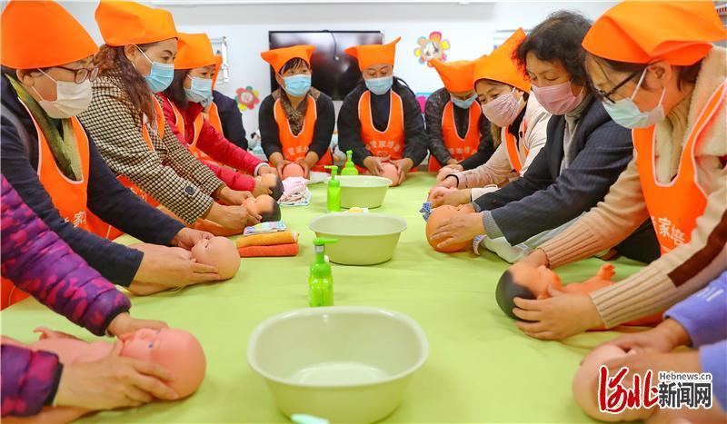 河北省秦皇岛市海港区一家家政培训企业内,学员跟随指导教师学习母婴